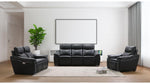 Modern living room with black leather sofa set and decorative elements.